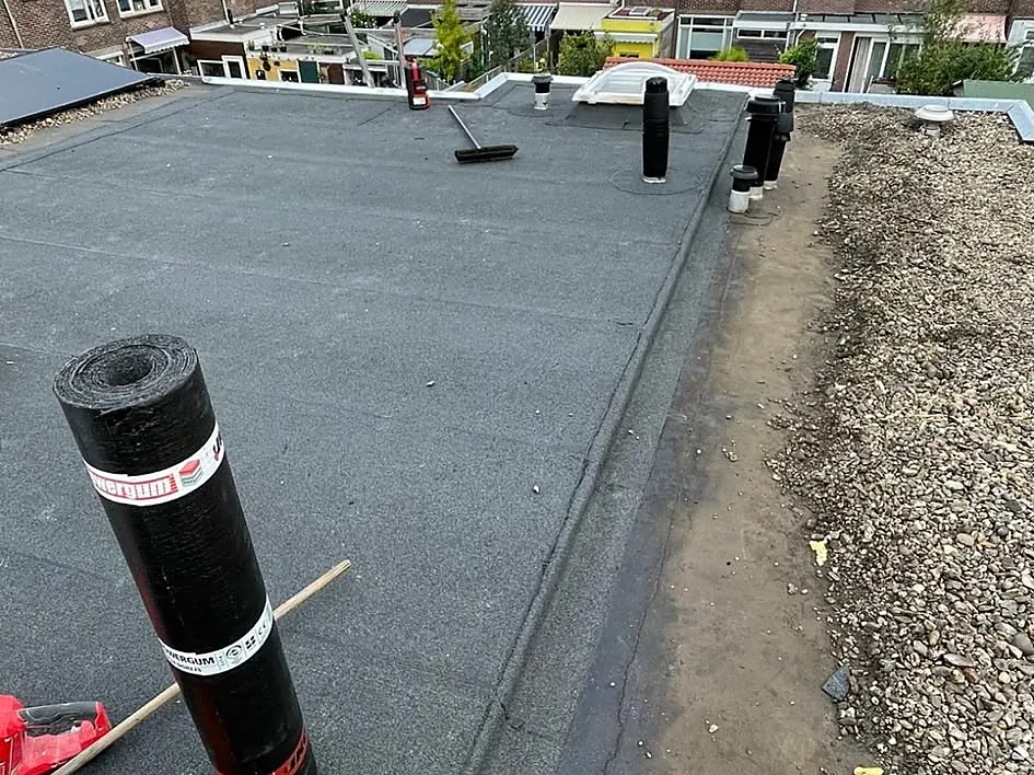 Groot plat dak van een rij woningen met nieuwe bitumen dakbedekking